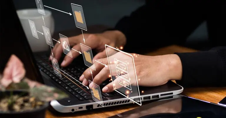 Close-up of hands typing on a laptop keyboard with holographic icons representing digital files and folders floating above. The icons are connected by lines, symbolizing data flow and organization