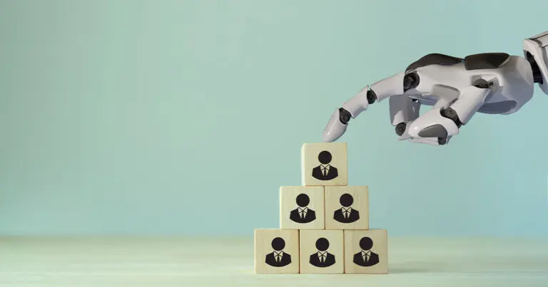 A stack of blocks in the shape of a pyramid with black images of a person on each block with a robotic arm coming in from out of frame tapping on the top block to represent AI hiring tools.