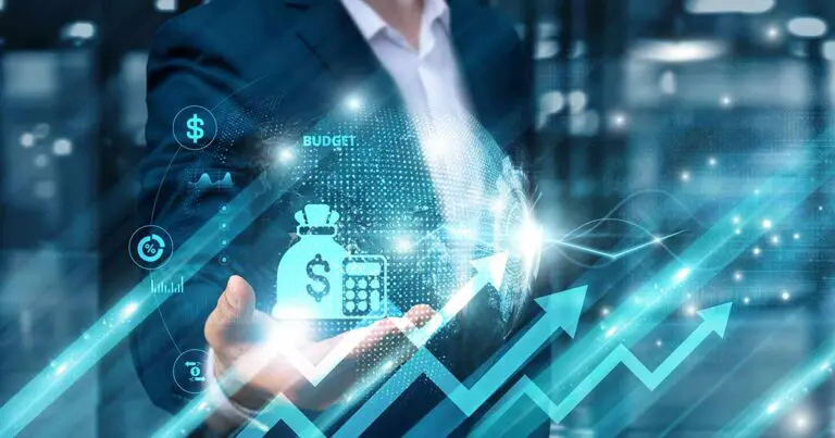 A business professional in a dark suit holds out a hand with a glowing digital projection of budget-related icons, including a money bag, calculator, and upward-trending arrows. The background features a modern, high-tech office environment with abstract data visuals and light effects symbolizing financial growth and planning.