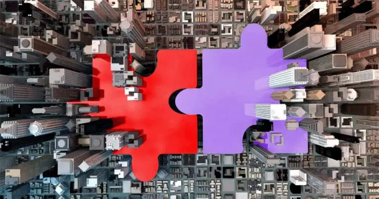 Aerial view of a dense cityscape split by two large interlocking puzzle pieces, one red and one purple, fitted together at the center. The contrasting colors cut through the buildings, symbolizing a merger or connection within an urban, data-driven landscape. The composition conveys themes of integration and strategic alignment tied to AI-driven brand visibility and the adobe semrush acquisition.