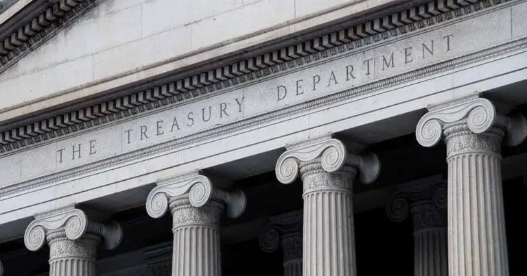 Neoclassical stone facade with a row of ornate columns beneath a carved entablature reading “THE TREASURY DEPARTMENT.” The image emphasizes symmetry, solidity, and institutional authority through its architectural details.