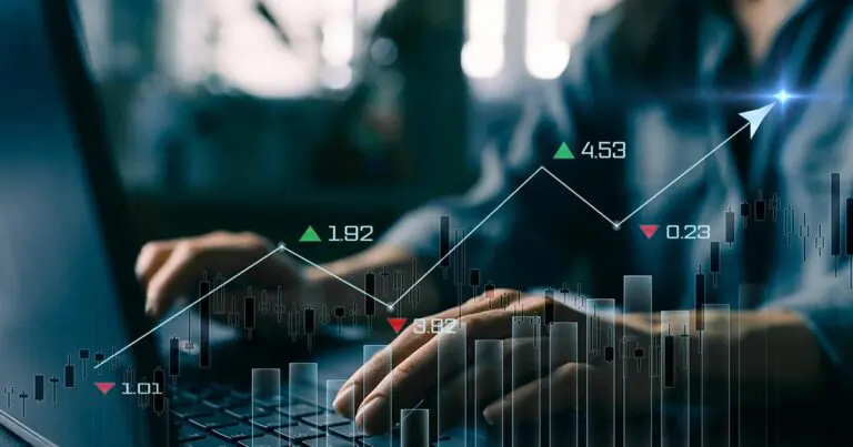 Hands typing on a laptop keyboard are overlaid with stock-style charts, candlestick graphs, and upward and downward indicators, including an arrow trending upward to suggest changing economic data. The illustration represents analysis of employment and financial metrics, reinforcing the article's focus on how the unemployment rate alone does not tell the full story of the labor market.