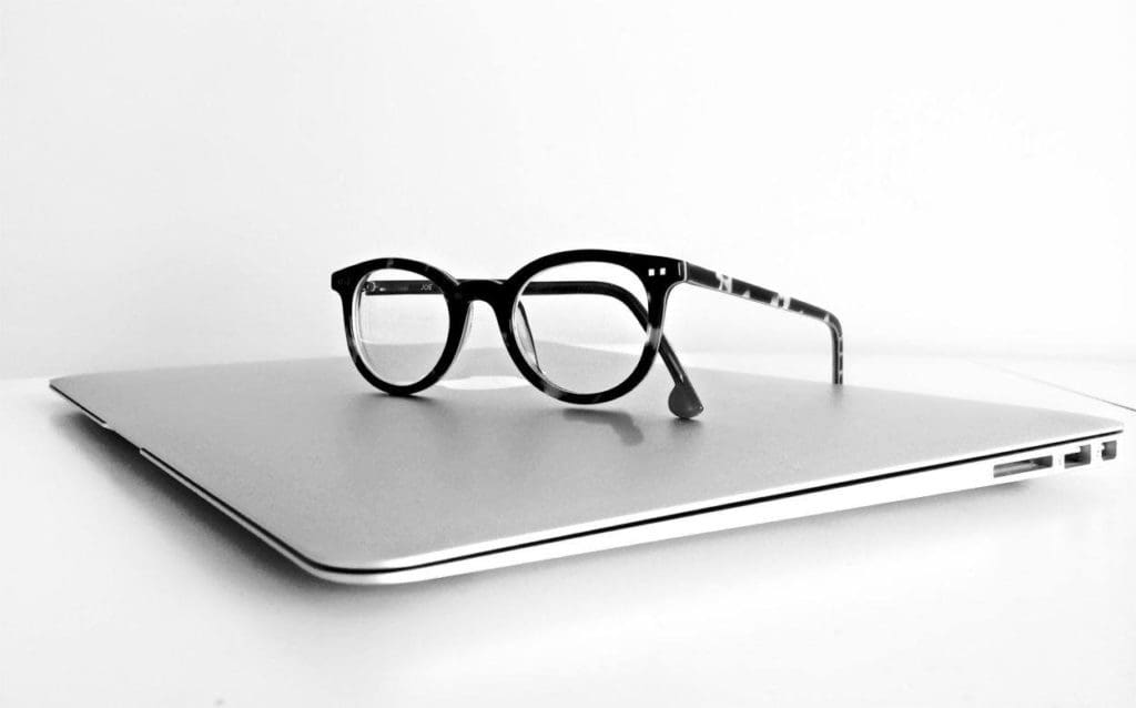 a pair of reading glasses on top of a laptop