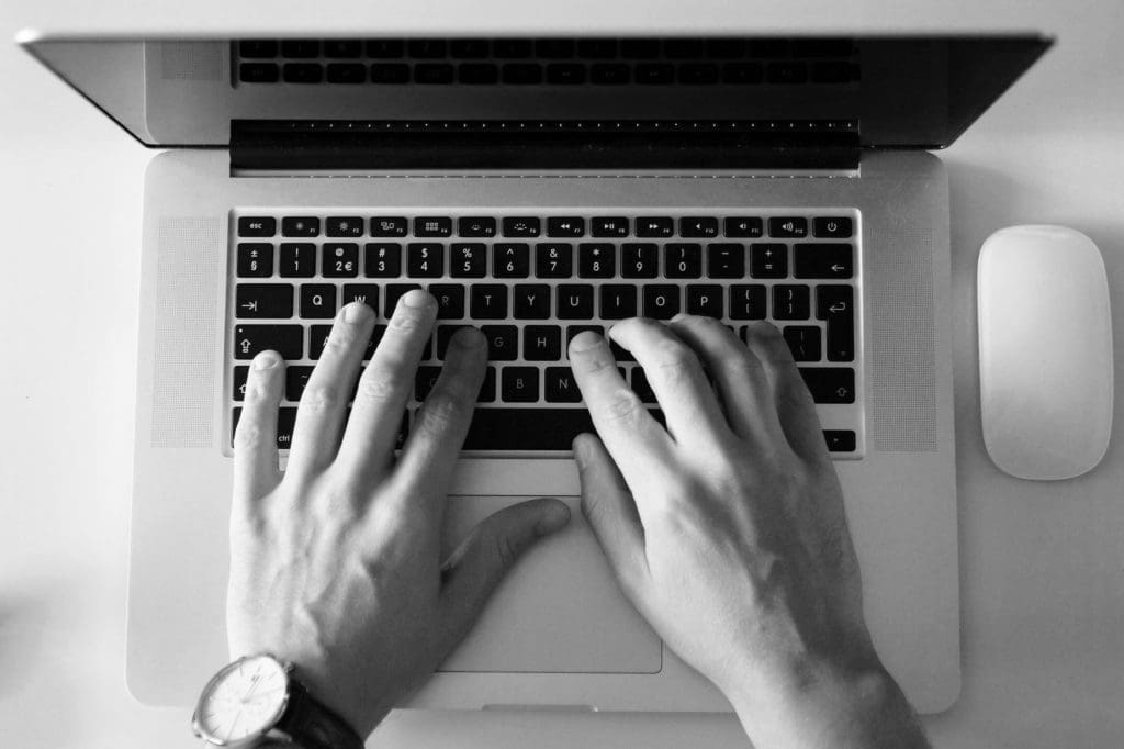person's hands on a laptop keyboard