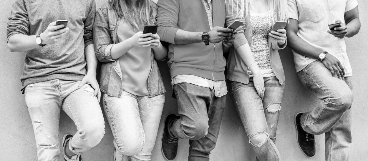 several young people in casual looking at their smartphones