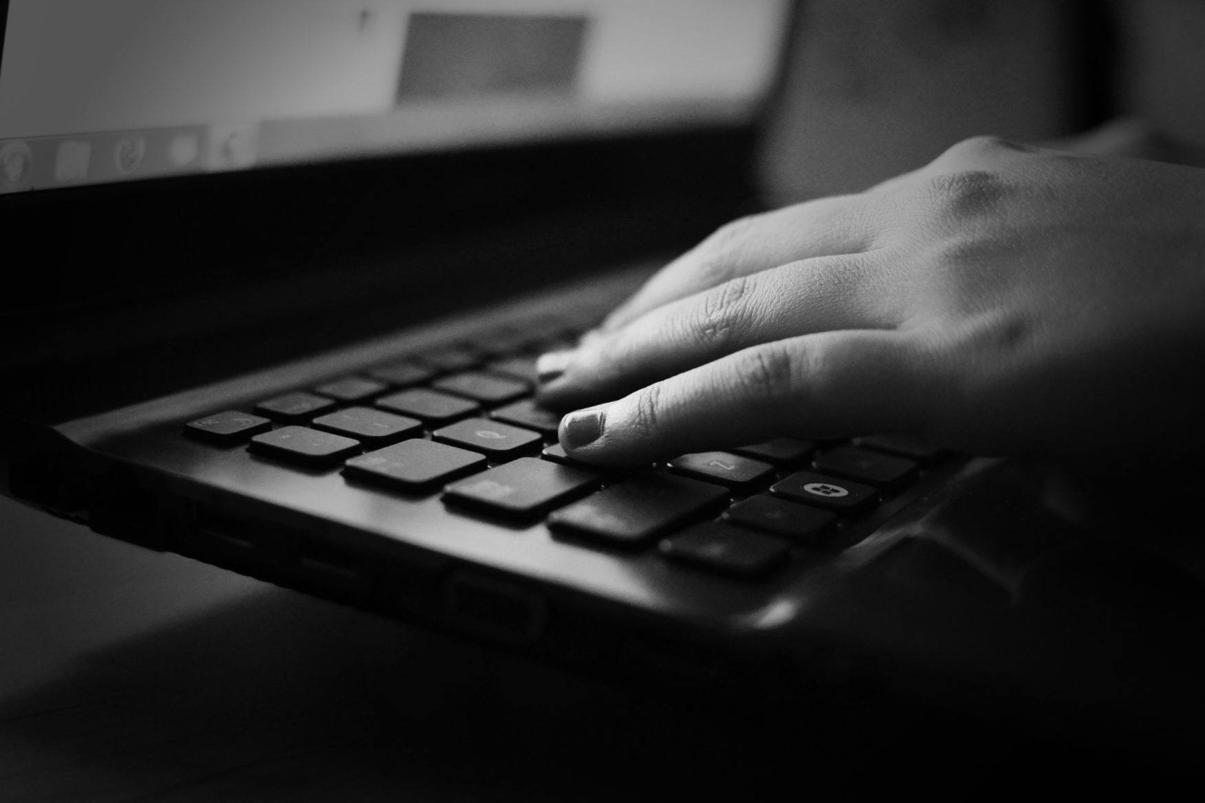 woman's hand on top of a laptop keyboard