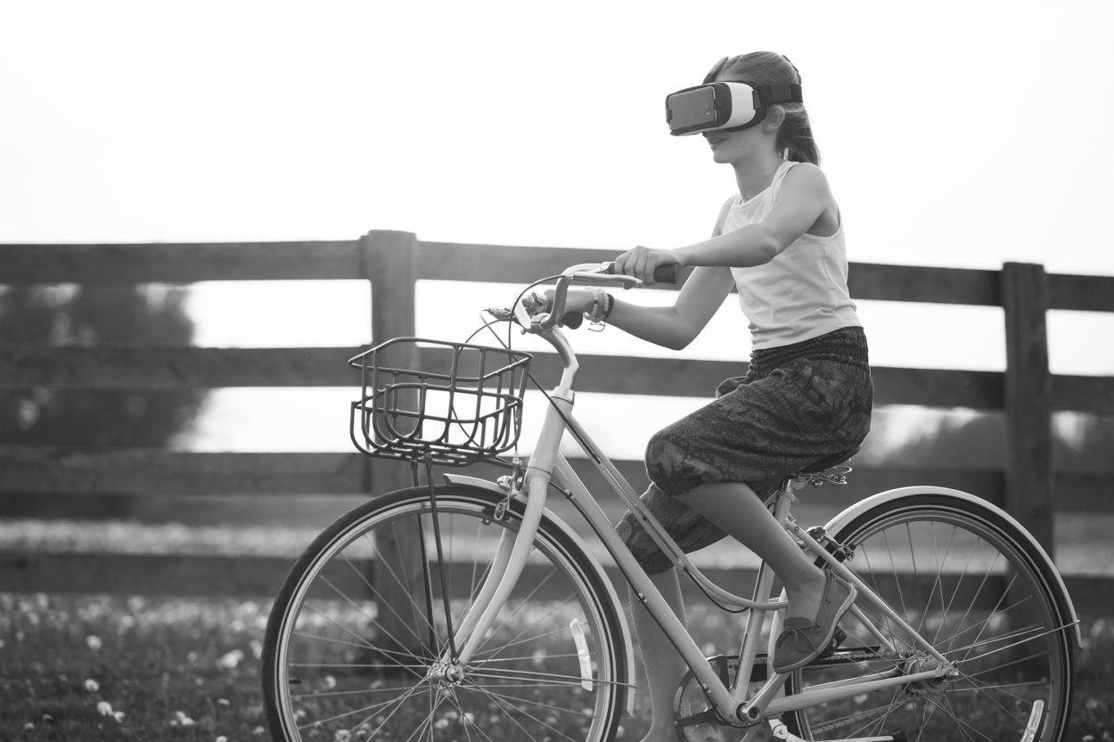 young woman riding a bicycle wearing a virtual reality headset