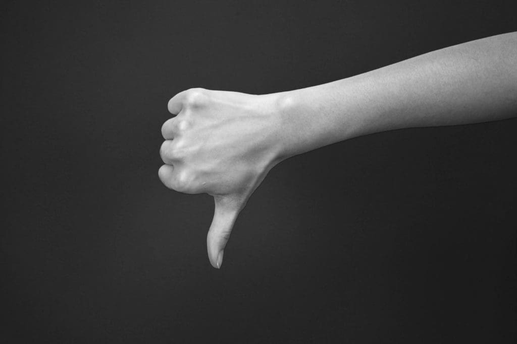 person's arm showing thumbs-down sign