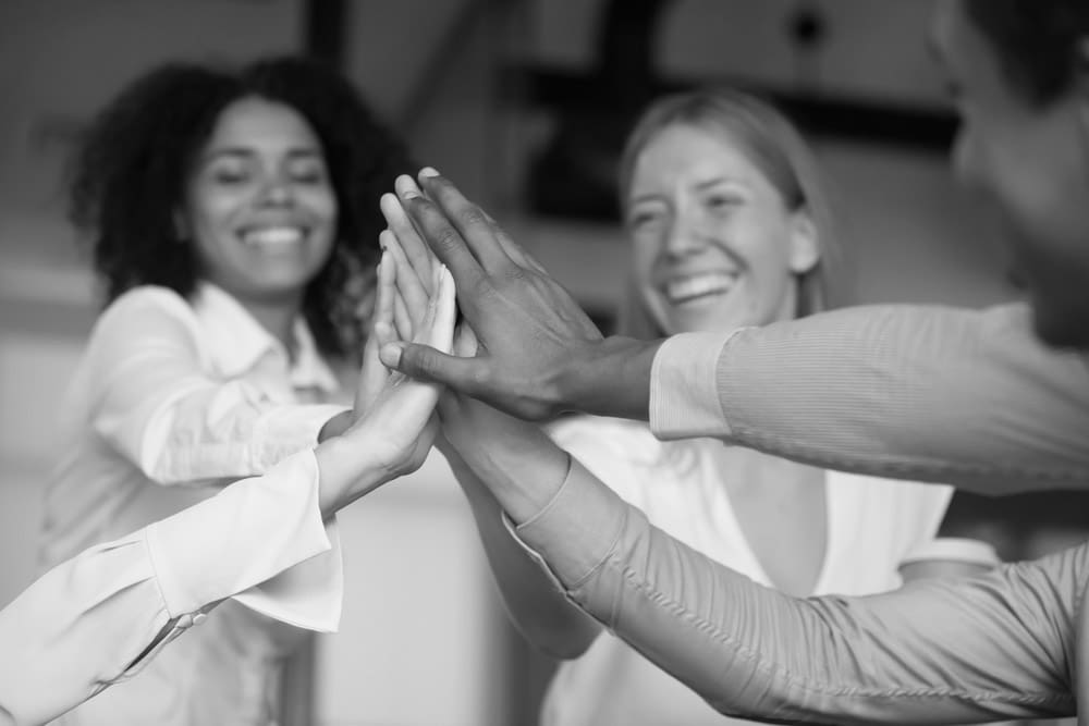 Business people smiling and high-fiving during a successful business meeting