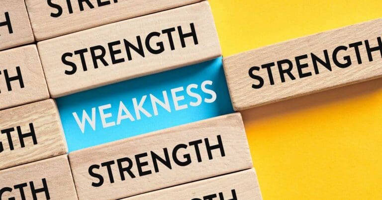 Wooden blocks with the word strength stamped on them with one block pulled away to reveal the word weakness underneath